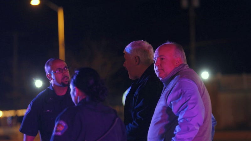Farmington police Chief Steve Hebbe, second from right, and City Manager Rob Mayes, right, speak with officers after a shooting Wednesday night north of the Bloomfield Highway at Riverstone Drive.