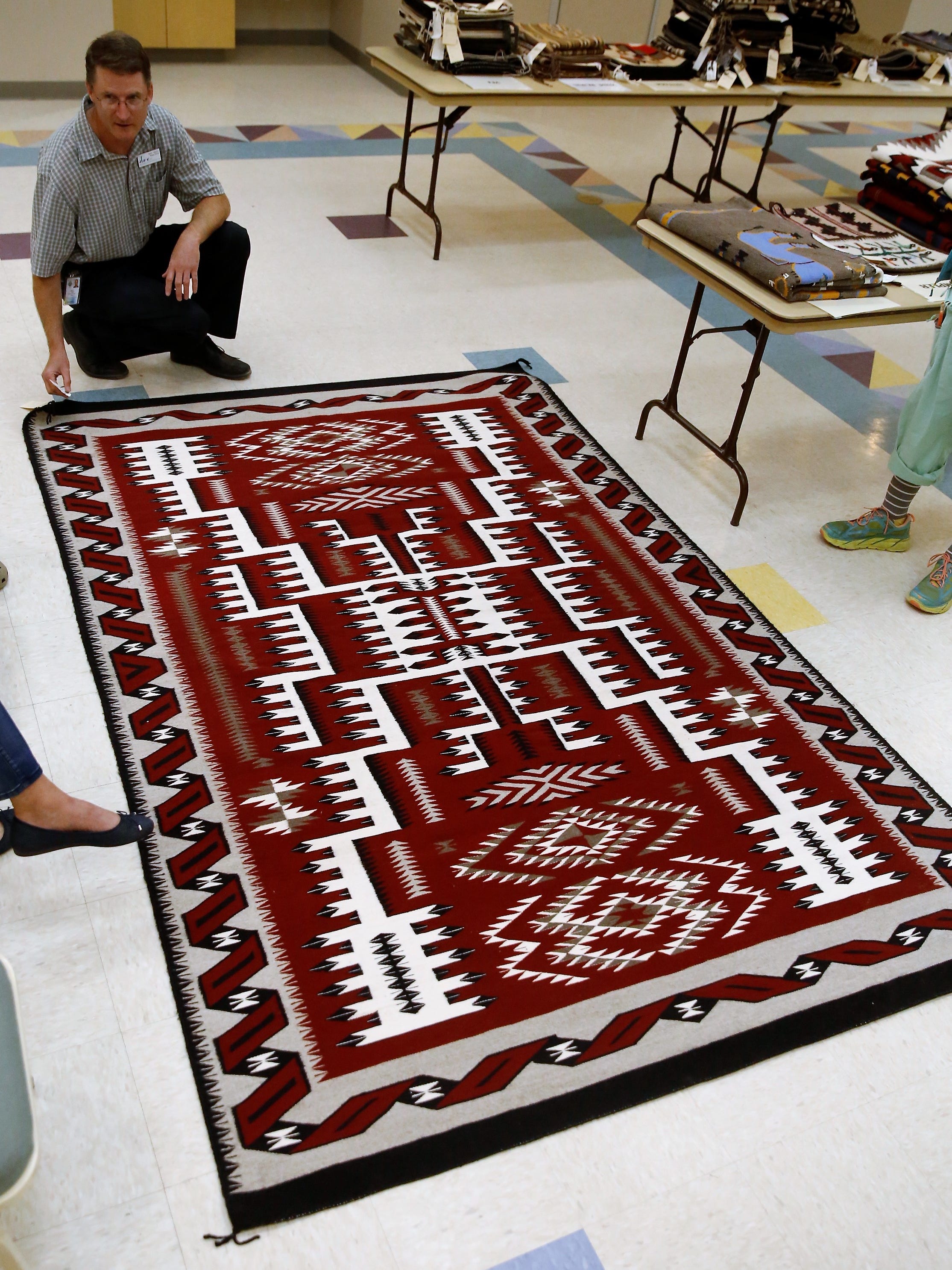 A storm pattern rug by Thelma James from the Shiprock Trading Post is displayed by Farmington Museum director Bart Wilsey Friday.