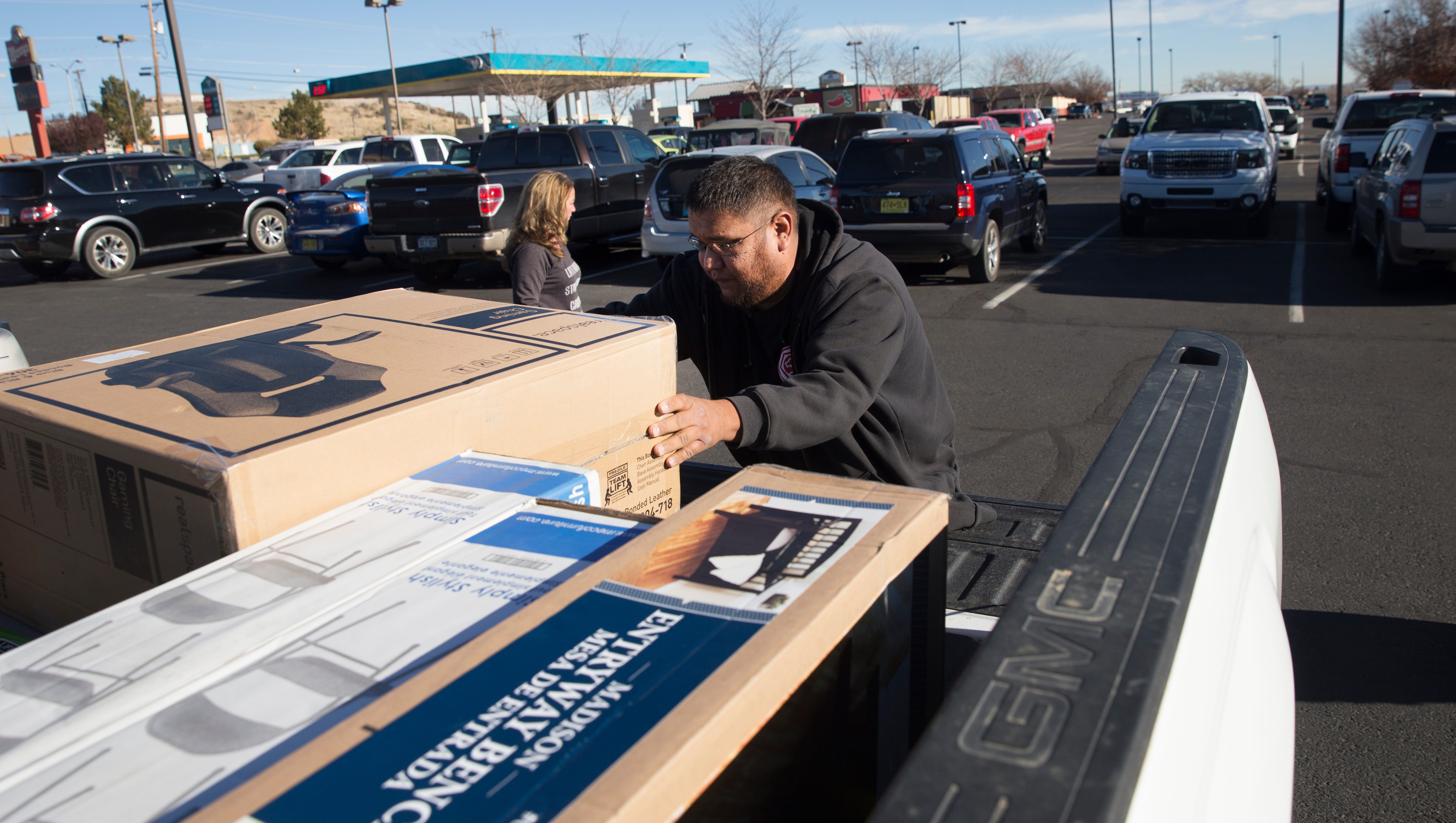Shopper Loren Harrison loads his purchases into his vehicle Friday at the Four Corners Marketplace in Farmington.