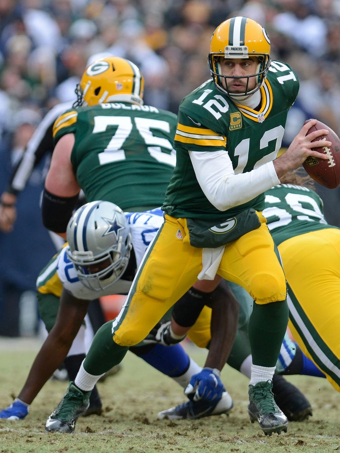 Green Bay Packers quarterback Aaron Rodgers (12) runs out of the pocket in the fourth quarter of Sunday's game against the Dallas Cowboys at Lambeau Field in Green Bay.