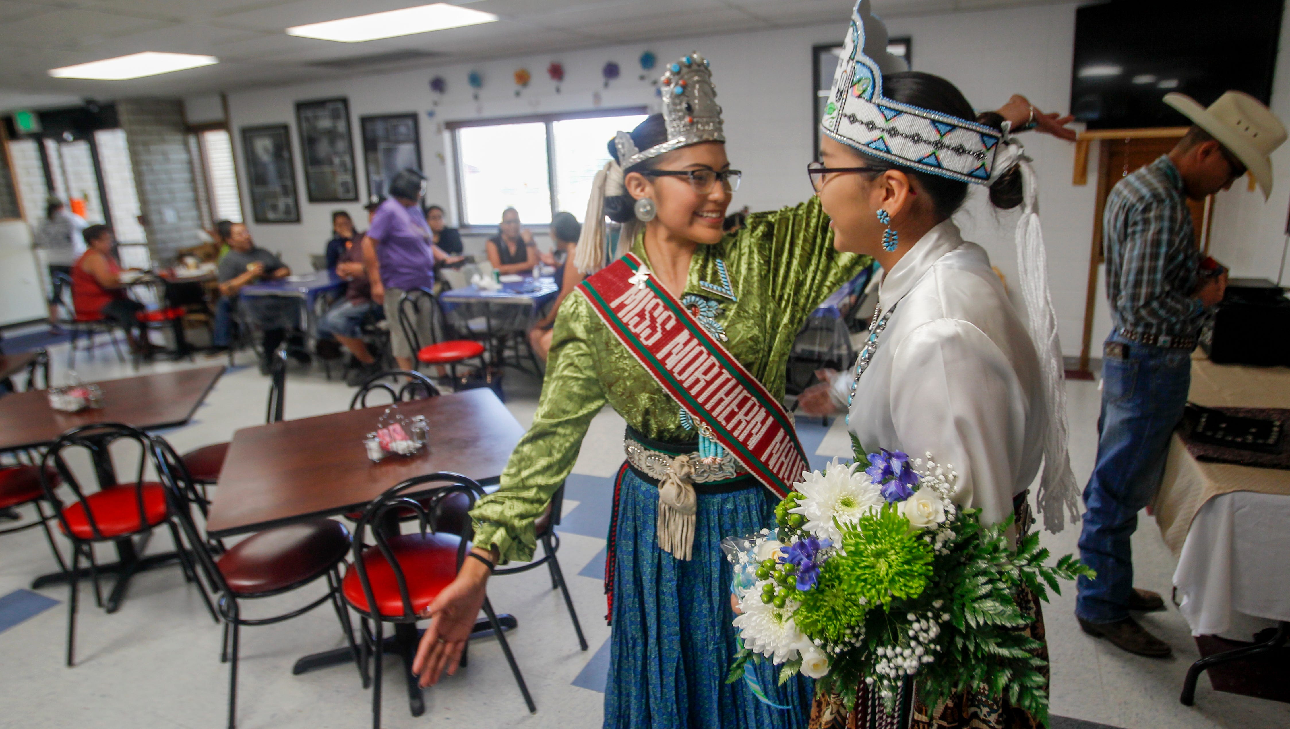 Miss Northern Navajo Ariana Roselyn Young, left, reaches out to hug Farmington American Indian Ambassador Nikeisha Kee Thursday during a ceremony at the Farmington Indian Center.