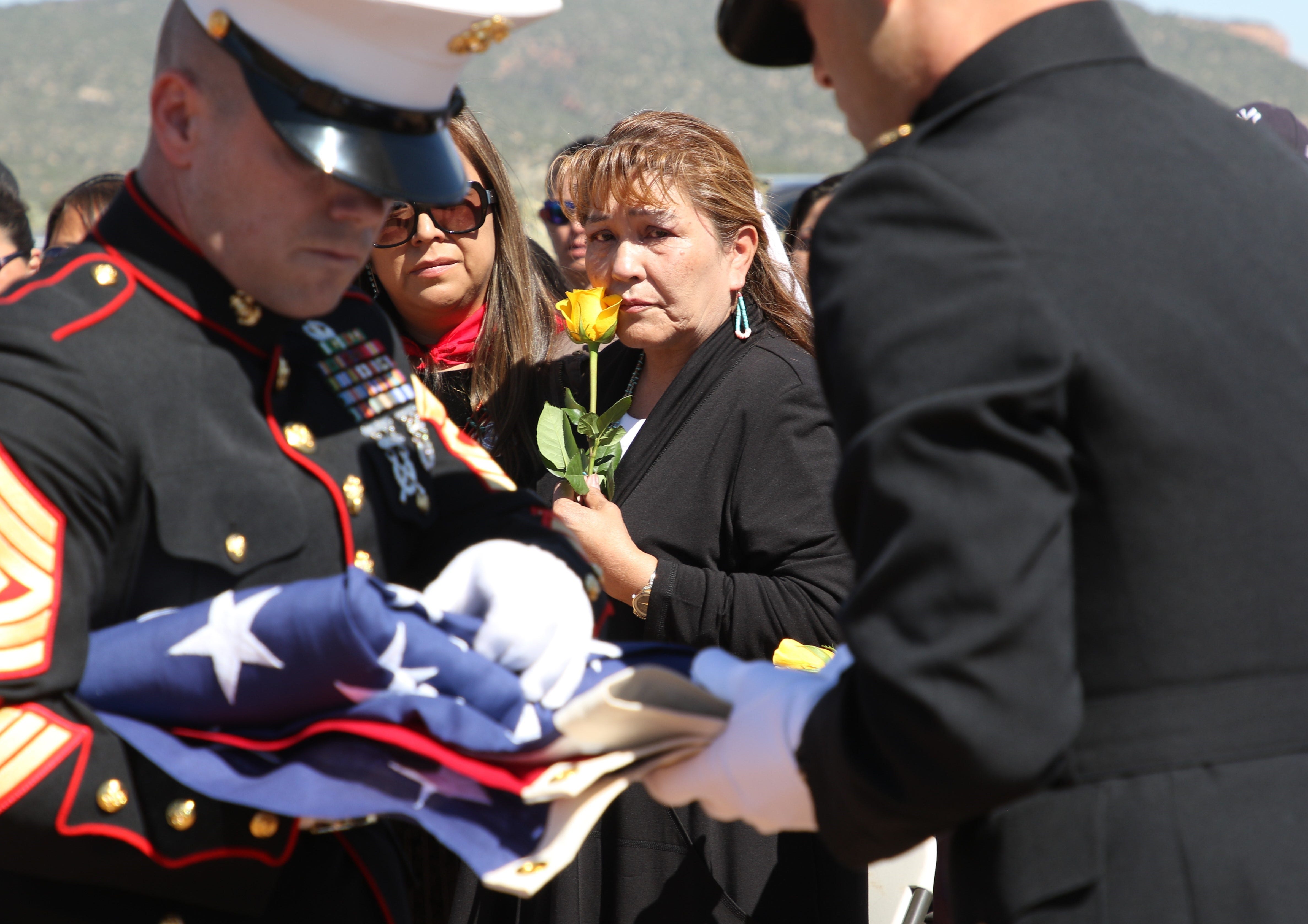 Vee F. Browne-Yellowhair, center, watches U.S. Marine Corps members fold the burial flag for her father, Navajo Code Talker William Tully Brown Sr., on June 6 at the Fort Defiance Veterans Cemetery in Fort Defiance, Ariz.
