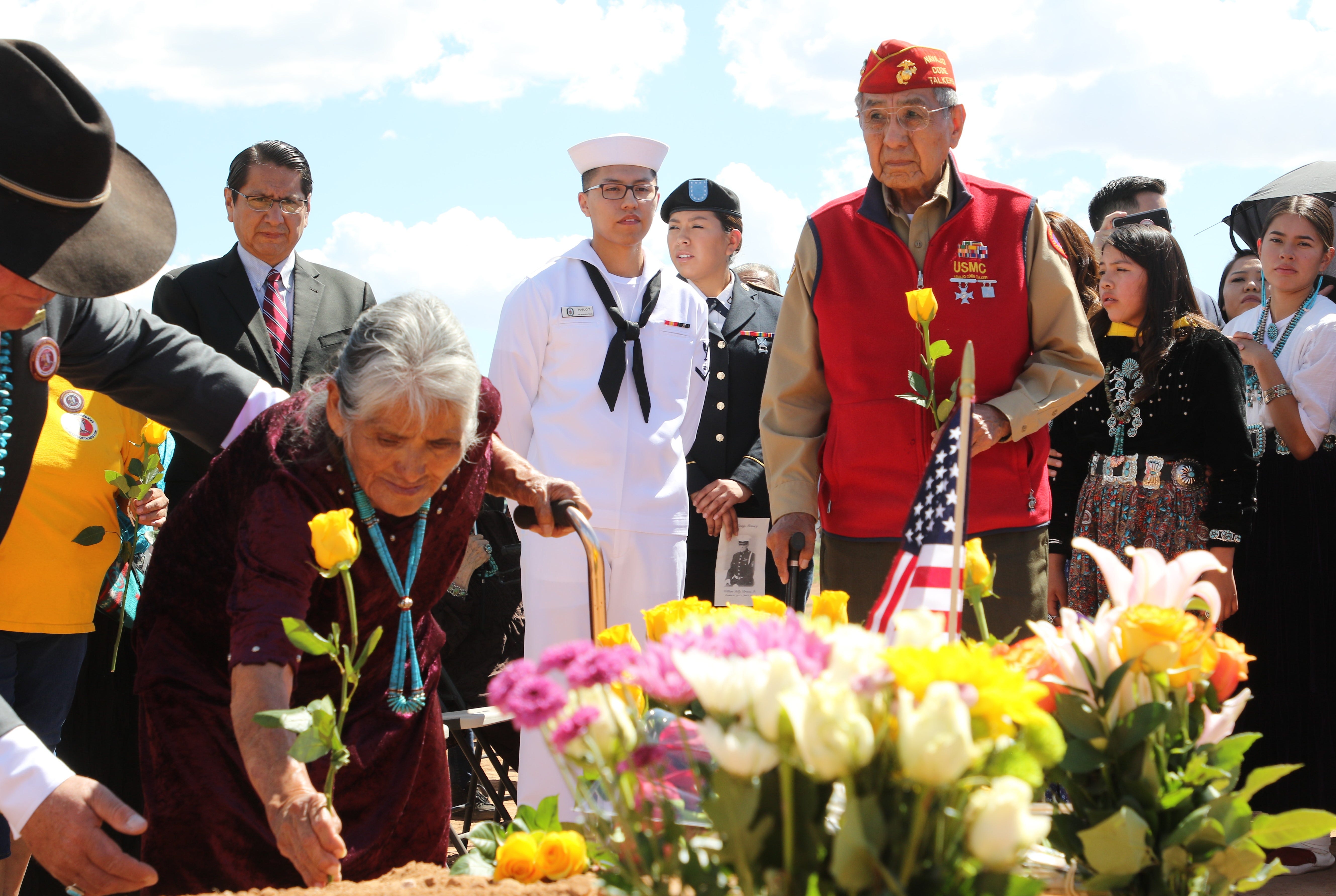 Navajo Code Talker Peter MacDonald Sr. waits to place a rose on the grave of Navajo Code Talker William Tully Brown Sr. on June 6 at the Fort Defiance Veterans Cemetery in Fort Defiance, Ariz.