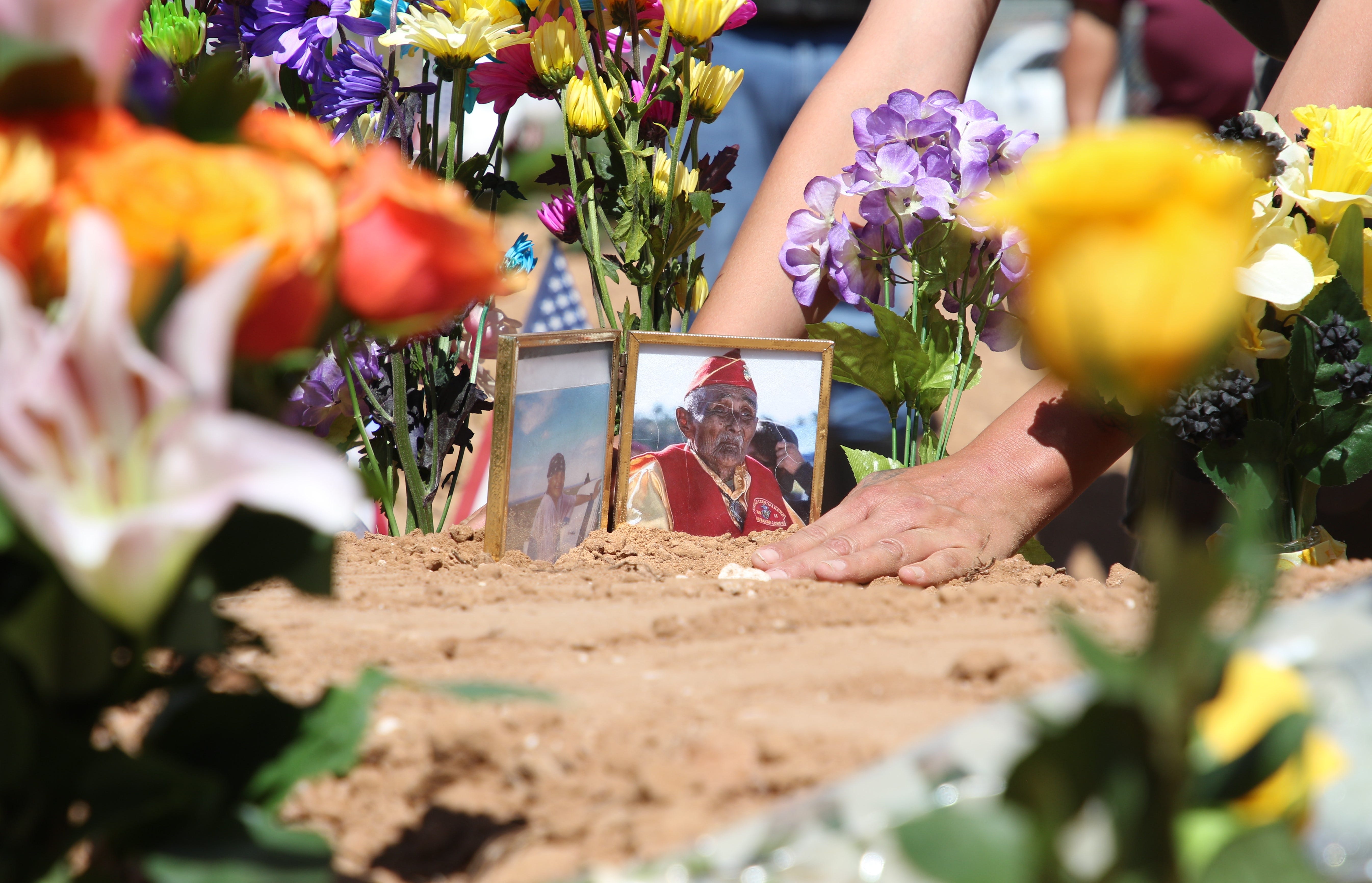 A photo of Navajo Code Talker William Tully Brown Sr. is placed on his grave at the Fort Defiance Veterans Cemetery on June 6 in Fort Defiance, Ariz.