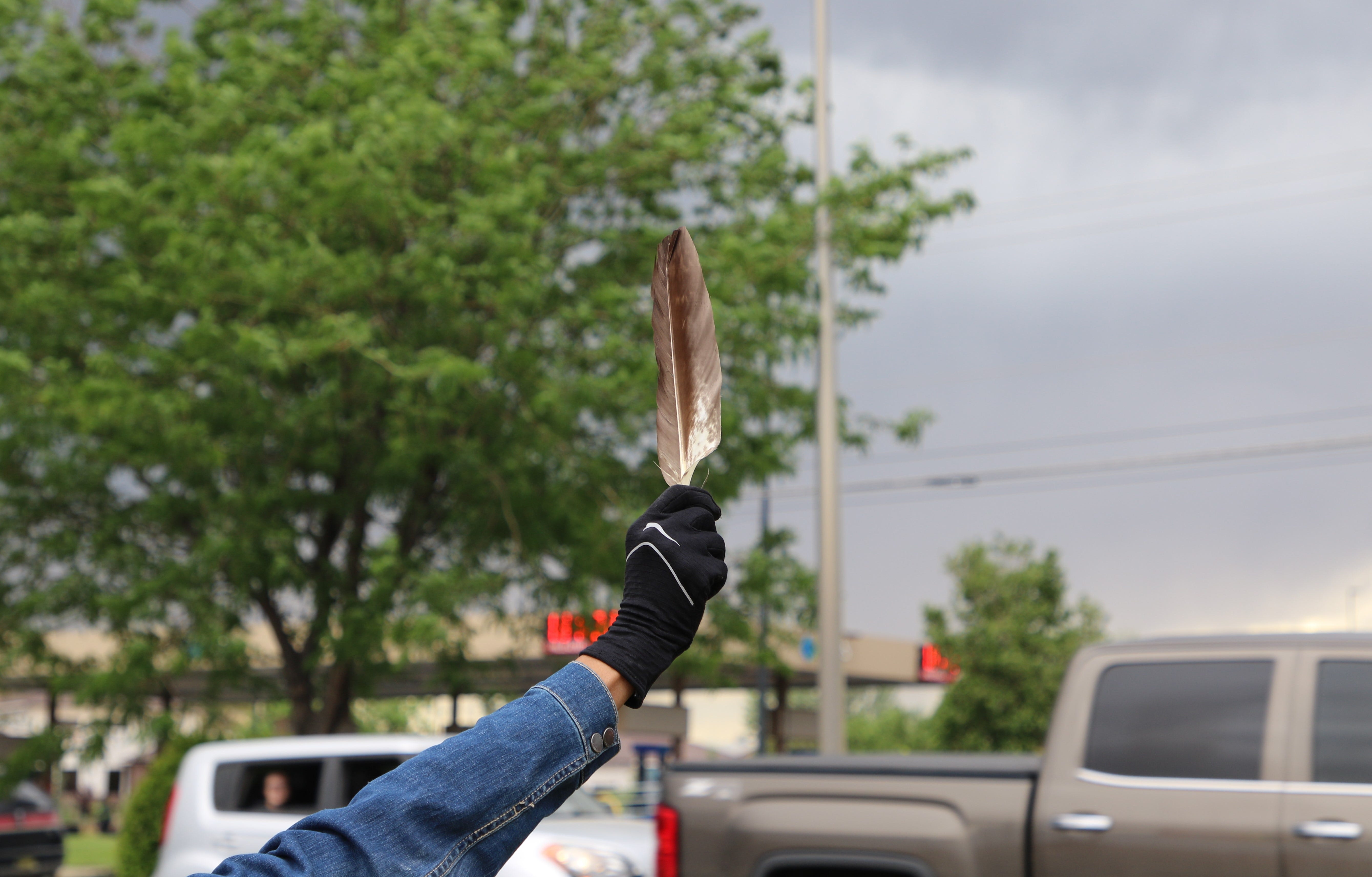 A protester holds an eagle feather on June 1 during the gathering that called for justice in George Floyd's deaths near the Animas Valley Mall in Farmington.