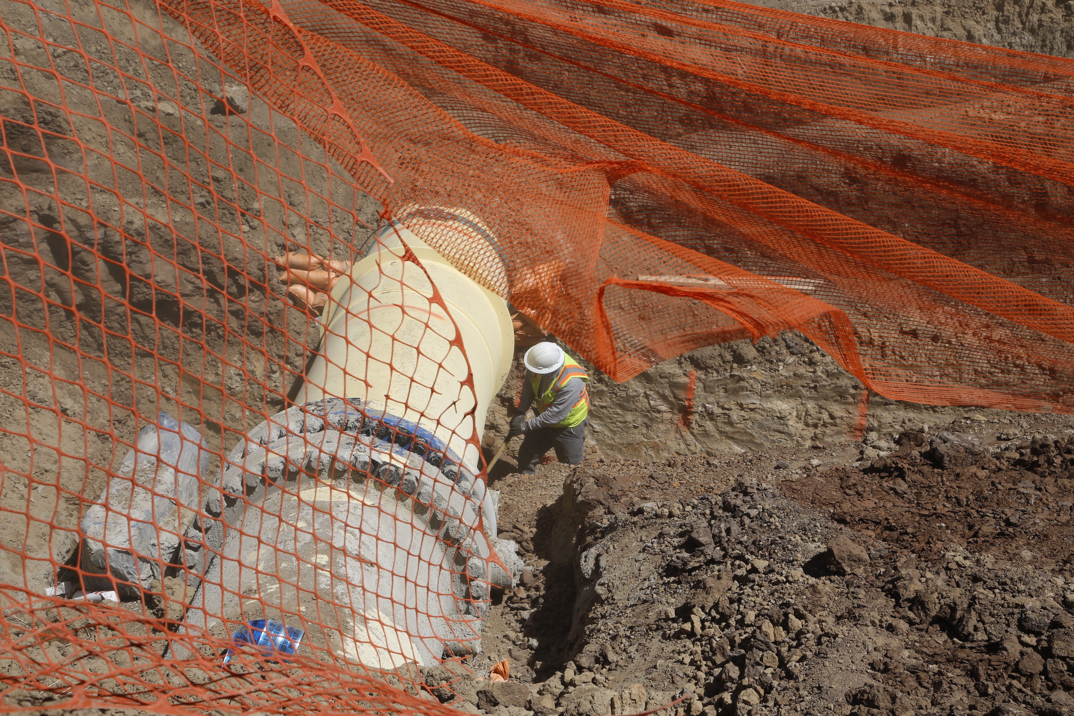 A construction worker shovels dirt from underneath a thrust block as part of the Navajo-Gallup Water Supply Project on April 15 in Sheep Springs.